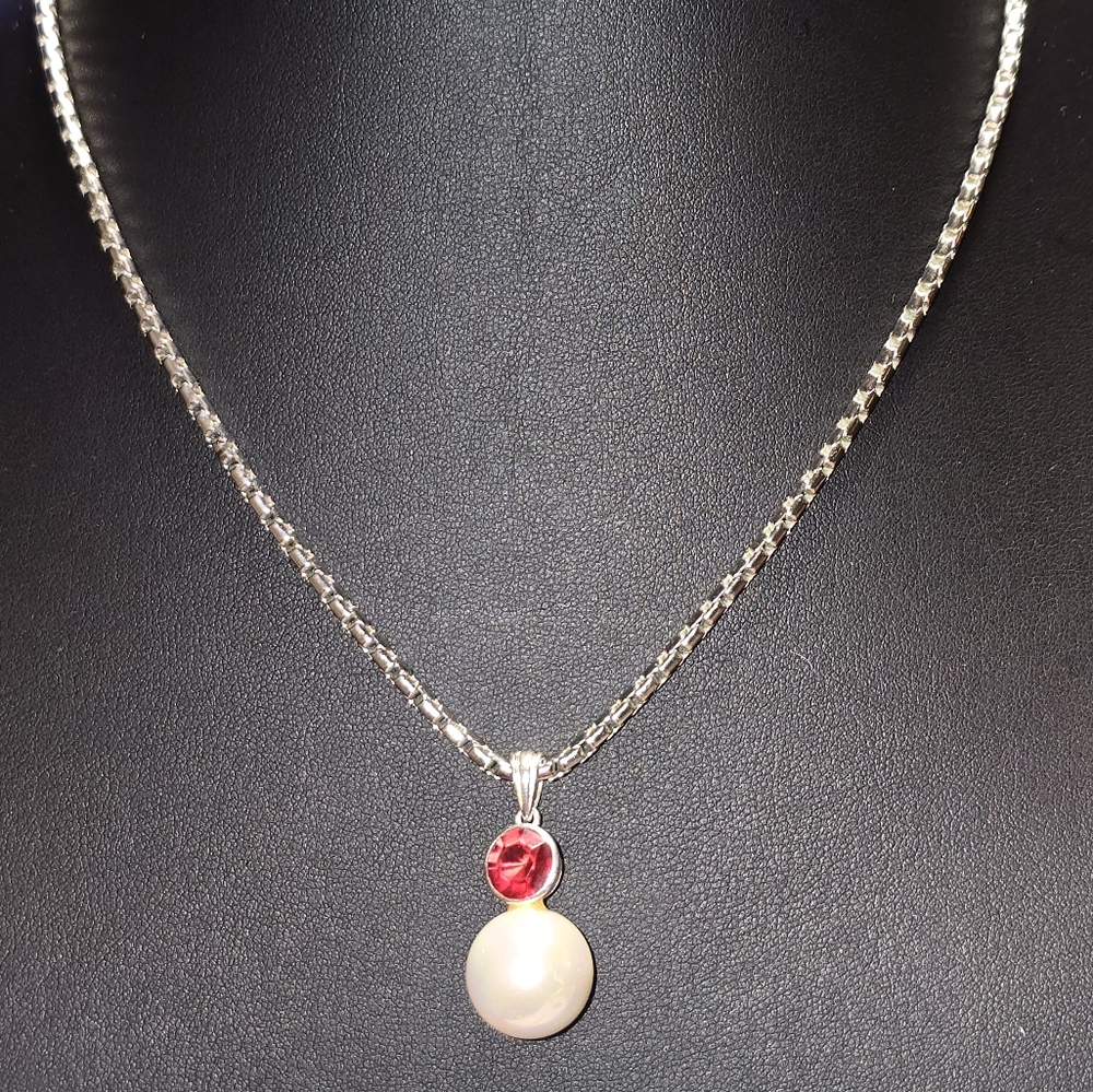 Pretty pearl pendant with a pop of red in a light catching faceted crystal. 18